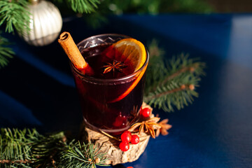 Christmas mulled wine with cinnamon stick, orange, anise and cloves on a blue background. Winter holidays.
