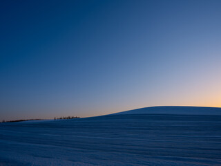 Fototapeta premium 雪の丘と夕焼け