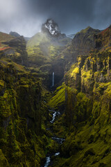 Beautiful gorge with waterfalls and snow capped mountains in Iceland.