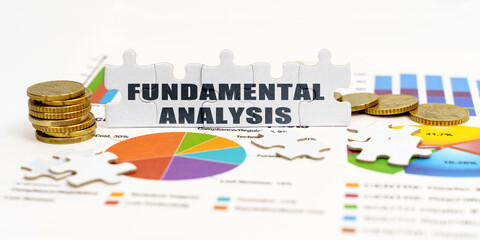 There are coins and puzzles on financial charts with the inscription - FUNDAMENTAL ANALYSIS