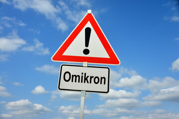 Hamburg, Germany - November 29, 2021: German Traffic warning sign with the note Omikron - symbolizes the danger from a new variant named Omicron or Omikron in German-speaking countries