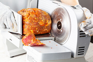 Close up isolated image showing a butcher or chef slicing a large frozen cured meat block. Turkish...