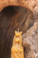 Woman-wolf beeswax candle placed on an old tree