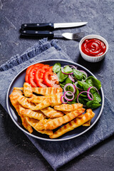 grilled chicken strips on a plate with vegetables