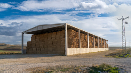 Fototapeta na wymiar Structure with concrete pillars and concrete roof used to store straw bales.