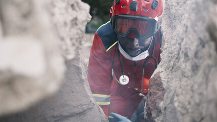 Tilt down view of African American paramedic talking with man suck under rubble of destructed...