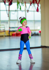 a small, beautiful girl,doing sports in the gym,in bright, colored sportswear