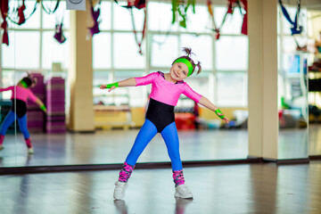 Fototapeta na wymiar a small, beautiful girl,doing sports in the gym,in bright, colored sportswear