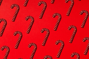 Christmas holiday pattern. Red canes on red background. Backdrop for your design.