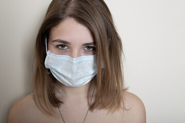 Portrait of a young sick woman in a medical mask isolated on a white background.