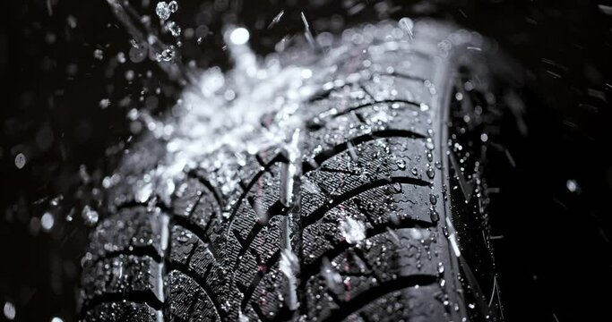 Water splashing on new car tyre in slow motion