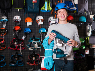 Young positive man chooses the gear for sports in store