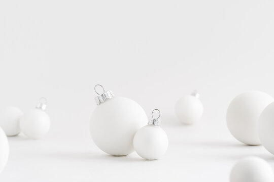 White Christmas balls on white background. Monochromatic holiday mockup.
