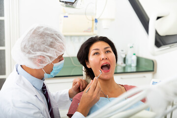 Male dentist with female patient during oral checkup in dentistry