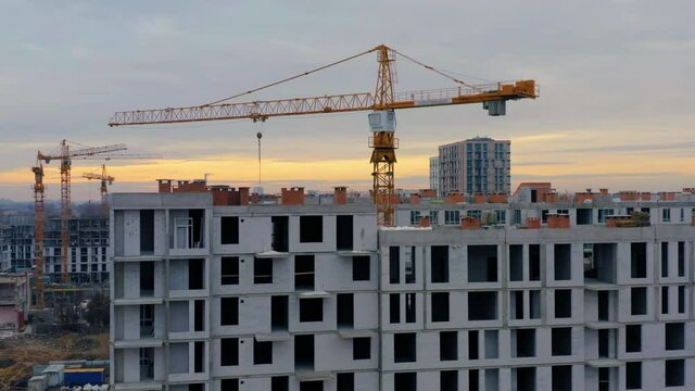 Aerial view of an almost built multi-storey residential building of aerated concrete blocks with a tower crane