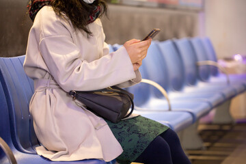 バス停で携帯電話をみる女性　woman