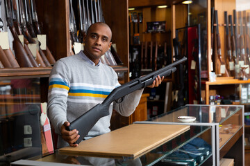 Gun shop salesman demonstrates a pump action shotgun