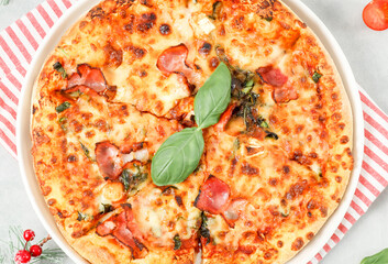 Round baked pizza in a plate with a red striped kitchen napkin