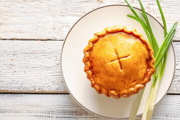 Plate with tasty beef pot pie on white wooden background