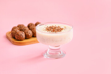 Tasty dessert with flax seeds and yoghurt in glass on color background
