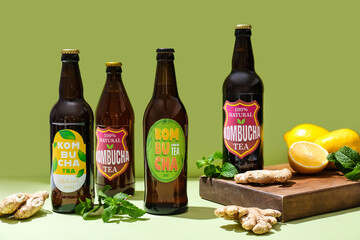 Bottles of different fresh kombucha with lemon and ginger on table