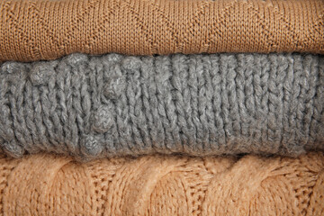 Stack of warm sweaters as background