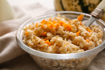 Bowl of tasty oatmeal with pumpkin on table, closeup