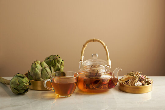 Artichoke Teapot In Golden Dish With Light Brown Background For Product Advertising , Front View , Food And Drink Content