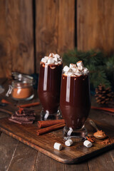 Glasses of tasty hot chocolate with marshmallows on wooden background