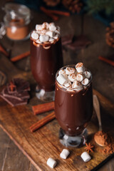 Glasses of tasty hot chocolate with marshmallows on wooden background