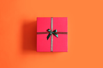 Beautiful Christmas gift box on orange background