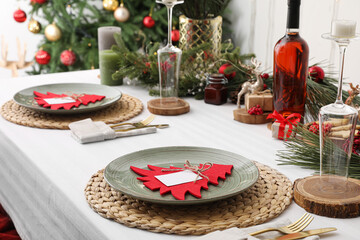 Dining table with beautiful setting for Christmas celebration and blank cards indoors