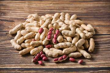 Dried peanuts in closeup on wood background