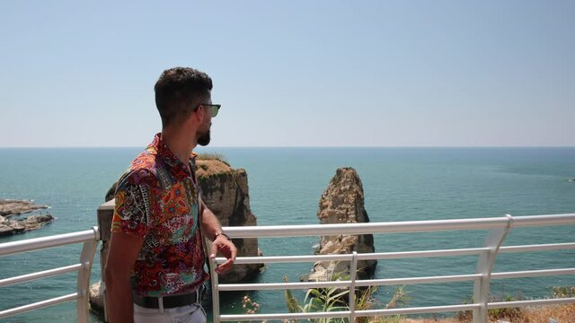 Lebanese man showing the famous Pigeon Rocks in Beirut, Lebanon