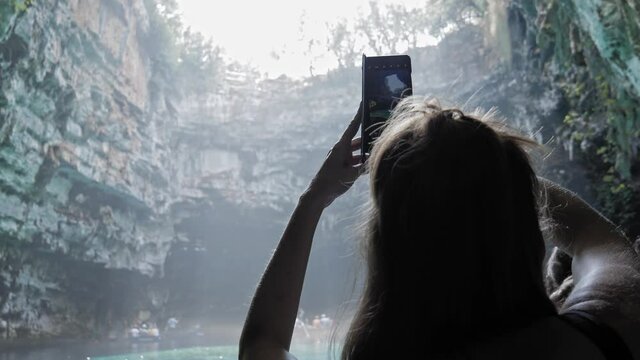 Tourist Taking Photos At The Scenic Melissani Cave on the island of Kefalonia, Greece - handheld shot