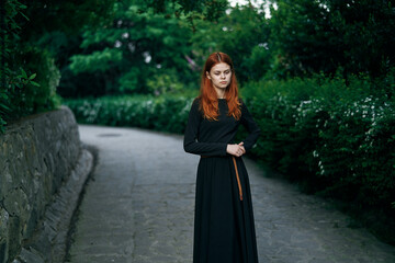 Naklejka premium woman in black dress nature walk garden trees fresh air
