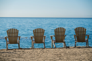 Adirondack chairs  on the sea coast invoke a vacation or retirement. 
