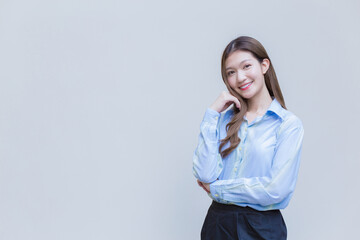 Young Asian business working woman with long hair who wear a blue long sleeve shirt smiles happily while she cross arms to present something on white background.