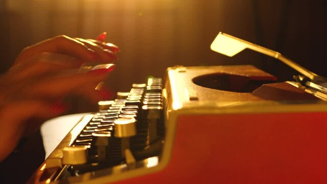 Woman's hand typing text on retro style mechanical typewriter. Paperwork in newspaper or media. Information journalism or reporter work on article or make story