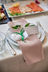 Table setting with plate with beige napkin and cutlery on table, copy space. Place set at wedding reception. Table served for wedding banquet in restaurant
