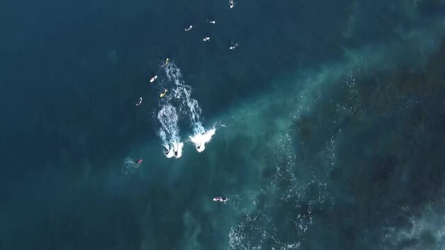 Birds Eye POV onto surfing people on the wave at Cronulla Point