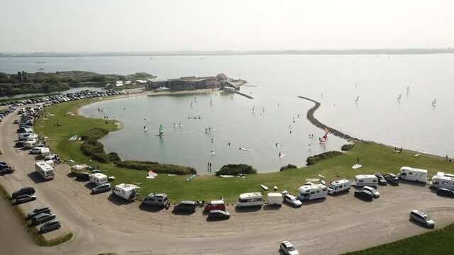 Small part of lake designated to learn windsurfing surrounded by campervans in The Netherlands, Brouwers dam