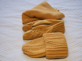 a set of warm yellow clothes. hat mittens and scarf