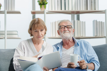 Fototapeta premium Elderly couple reading a book with smile and romantic emotion.