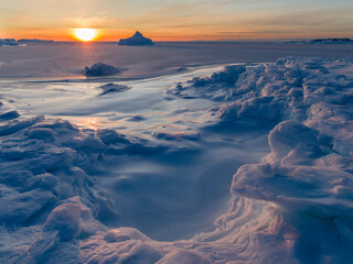 Sunset at the shore of frozen Disko Bay during winter, West Greenland, Denmark