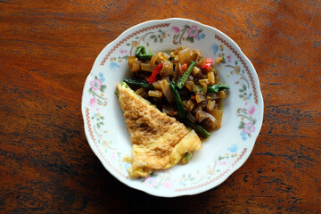 Photo of stir-fried kikil and omelette. Kikil is part of the cow's leg which consists of tendons. Kikil is usually cooked with green chilies to be stir-fried and seasoned with shallots, galangal