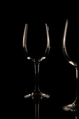 Set of empty crystal wine glasses, with black background and transparent tones.