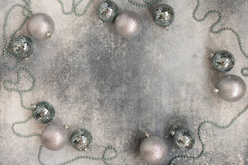 Christmas decoration with shiny beads and silver balls on a gray background. Top view.