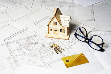 Model of a house and key ring, plan project and drawings on paper with copy space