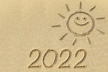 Drawing sun and 2022 on the sand